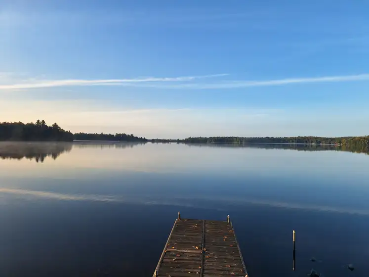 Wooden dock on a calm lake at sunrise