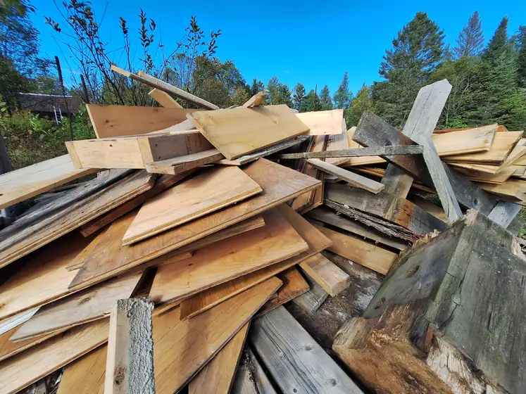 Stack of reclaimed boards under a blue sky