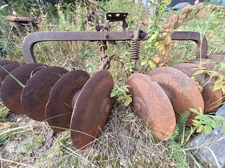 Rusted disc harrow resting in the grass