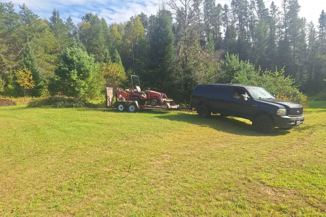 Dark truck and tandem trailer used for cleanouts, parked in South River
